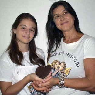 Woman and girl wearing Angels & Cookies t-shirts and holding a hear-shaped cookie together